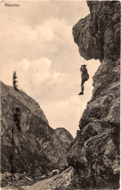 a person mountain climbing hanging from a rope