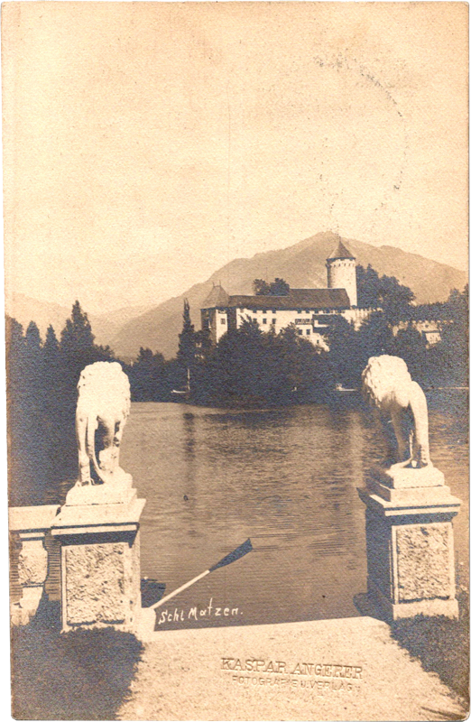 statues of lions on pillars next to a body of water