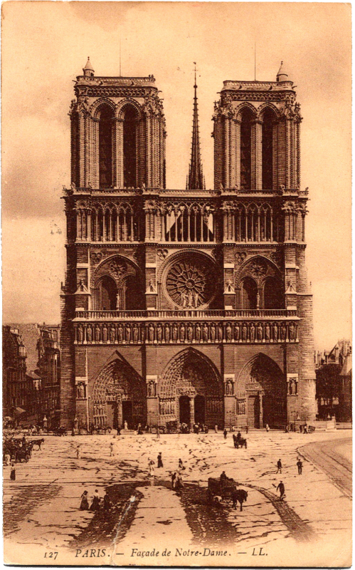 a large building with towers and people walking around