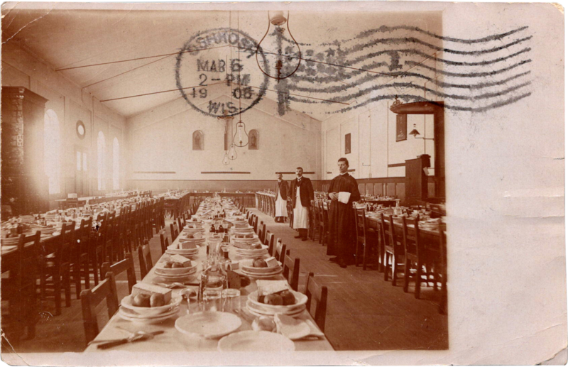 people standing in a room with tables and chairs