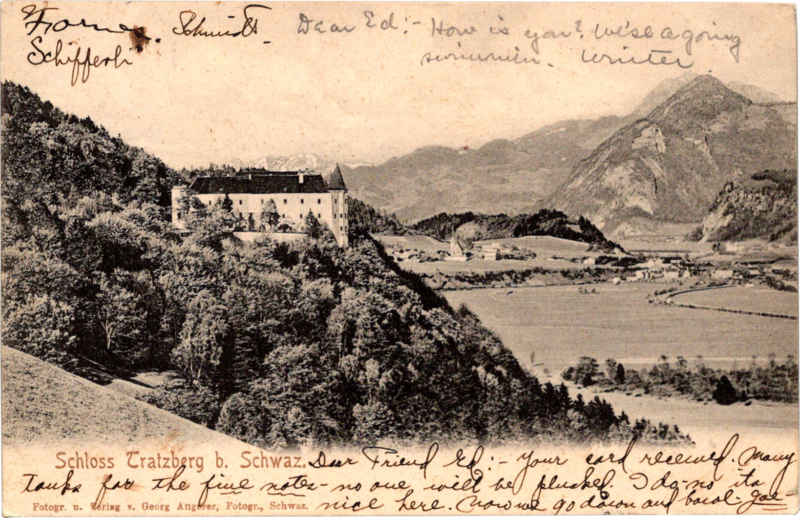 a building on a hill with a body of water and mountains