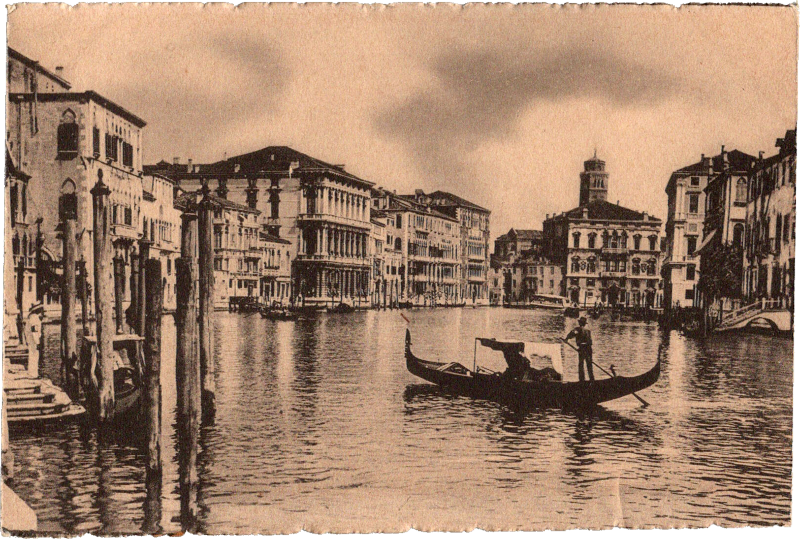a person on a boat in a canal with buildings in the background