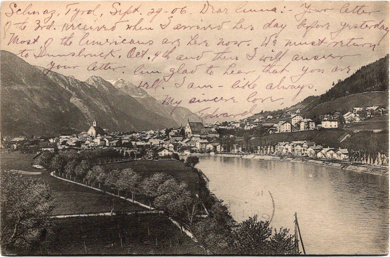 a river with a town and mountains in the background