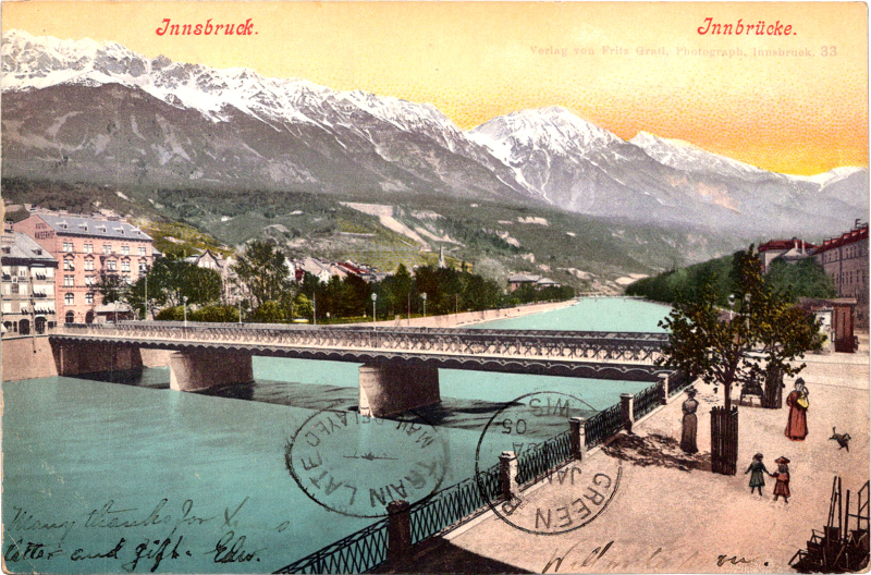 a bridge over a river with mountains in the background