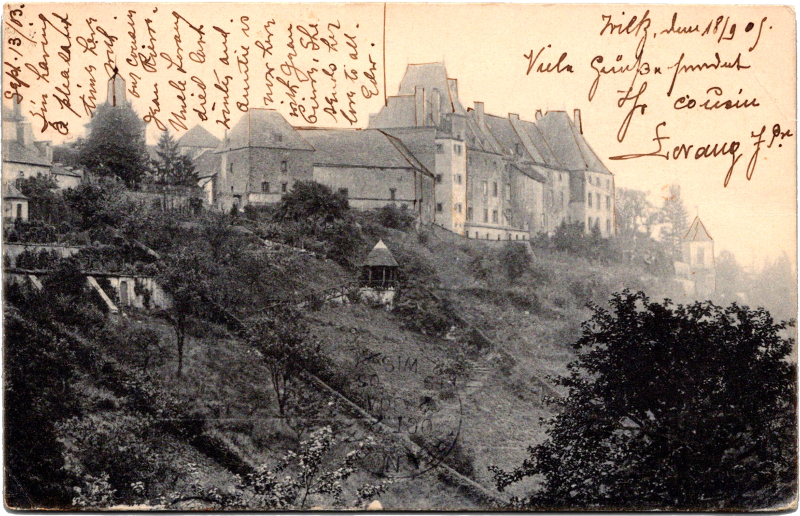 a building on a hill with trees and a building on the side