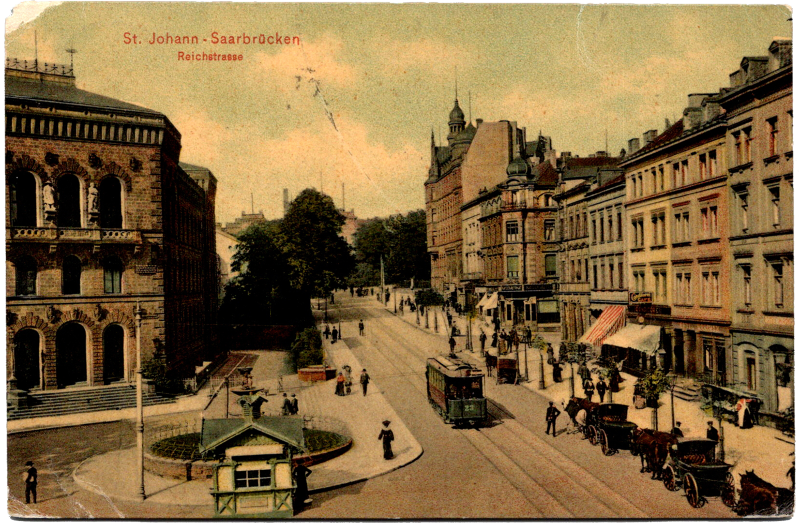 A picture of a city street with a horse drawn carriage.